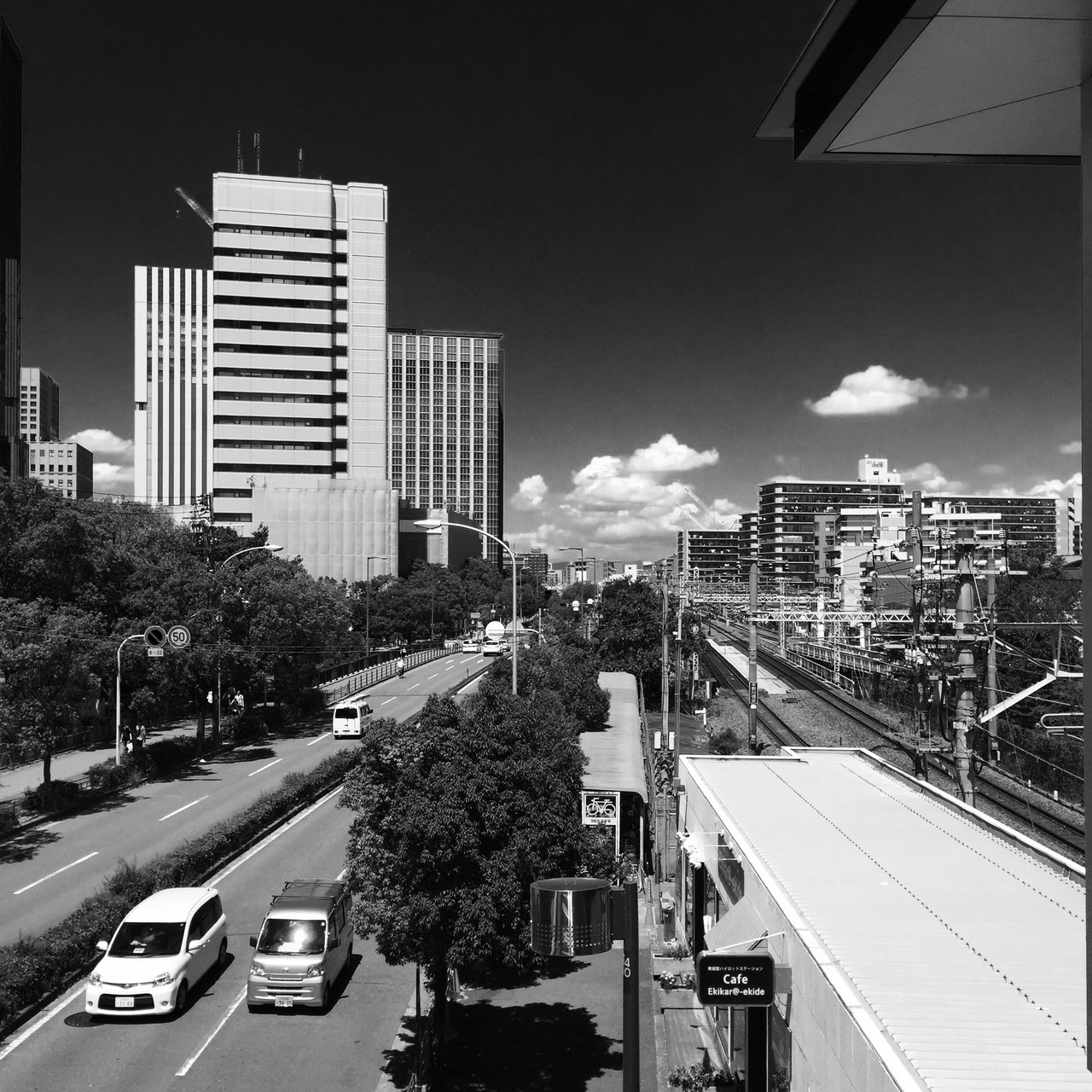Monochrome city view over a road and elevated railway lines