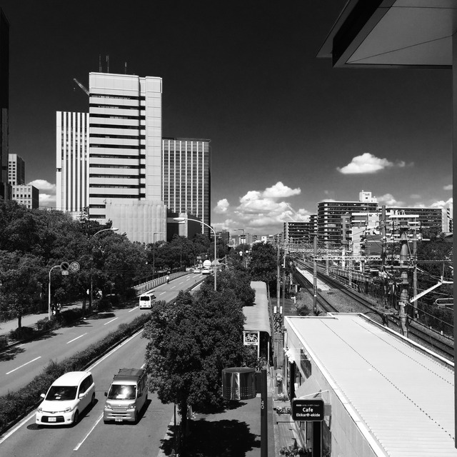 Monochrome city view over a road and elevated railway lines