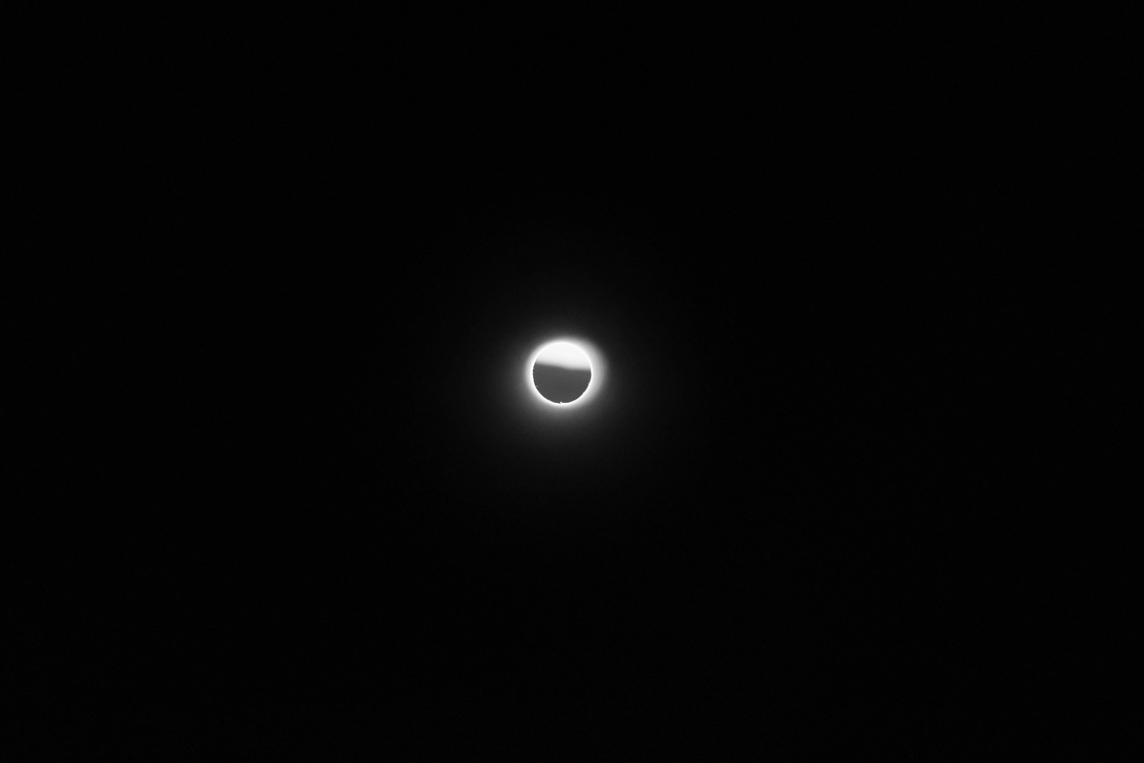 The moon shrouded in thin cloud, a bright halo in a black sky