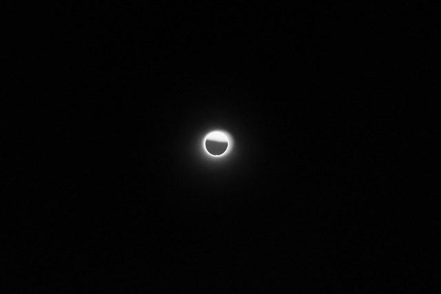 The moon shrouded in thin cloud, a bright halo in a black sky