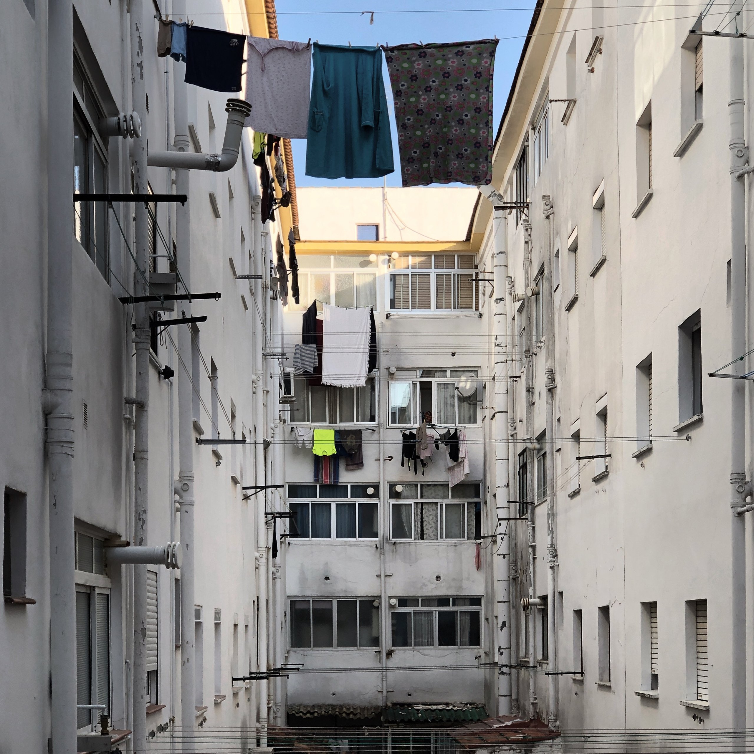 Washing strung between white apartment blocks in morning light