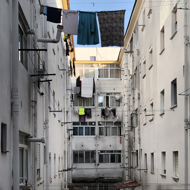 Washing strung between white apartment blocks in morning light