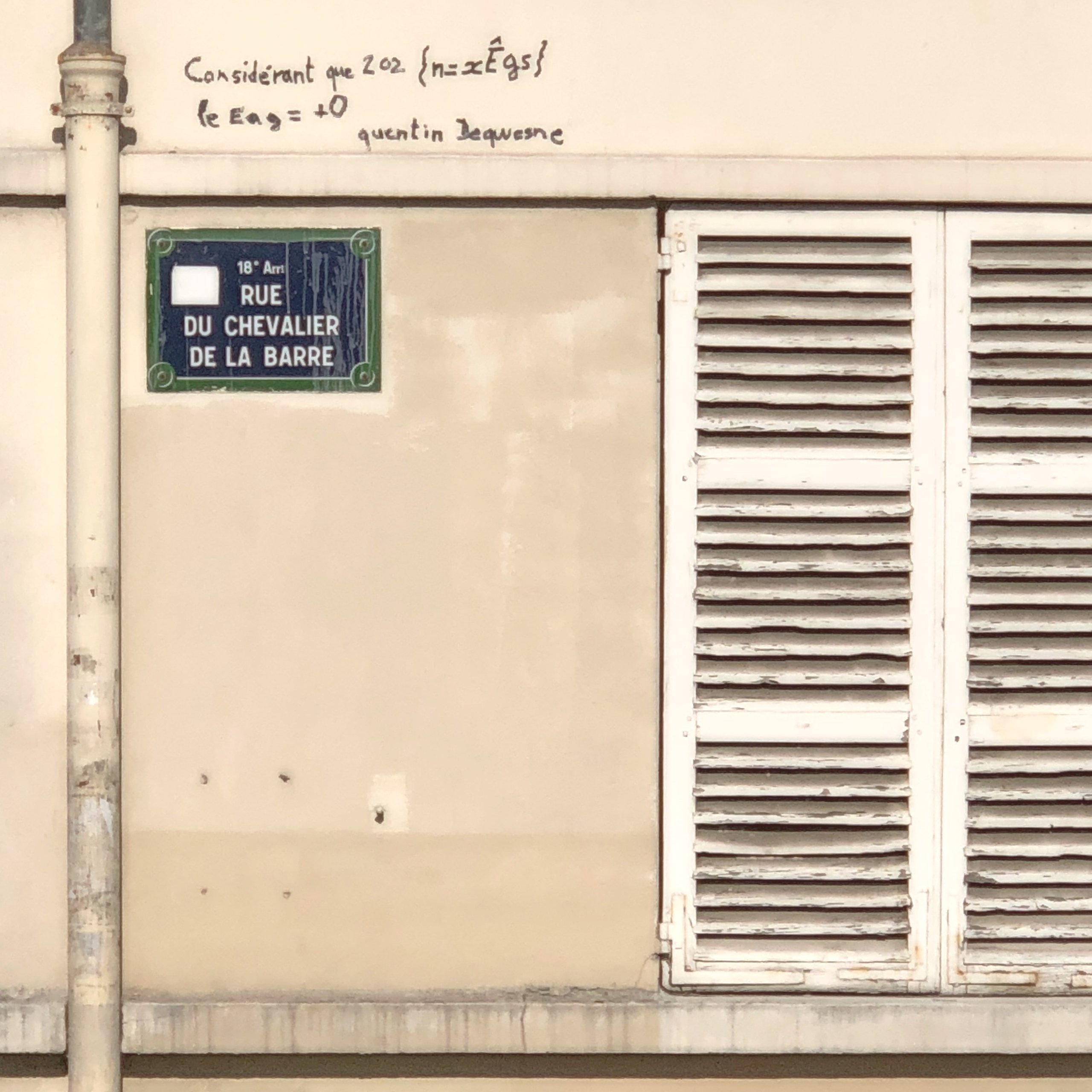 A scrawled theorem above the Rue du Chevalier de la Barre street sign