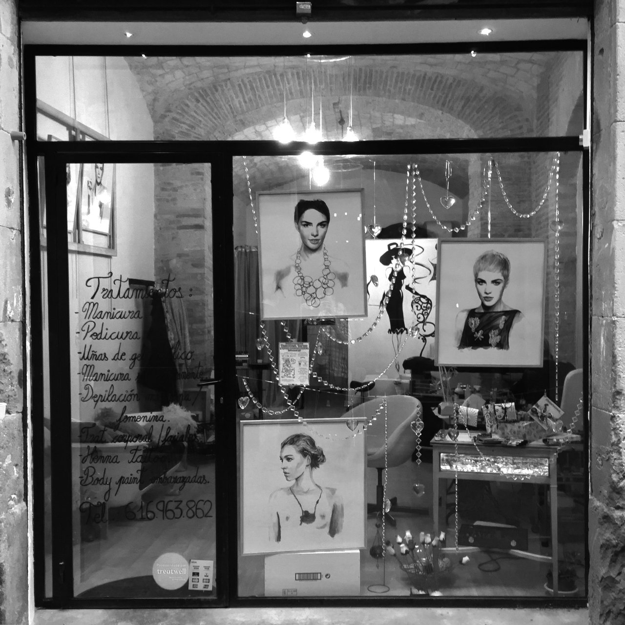 Monochrome salon window with fashion portraits and a chalked price list