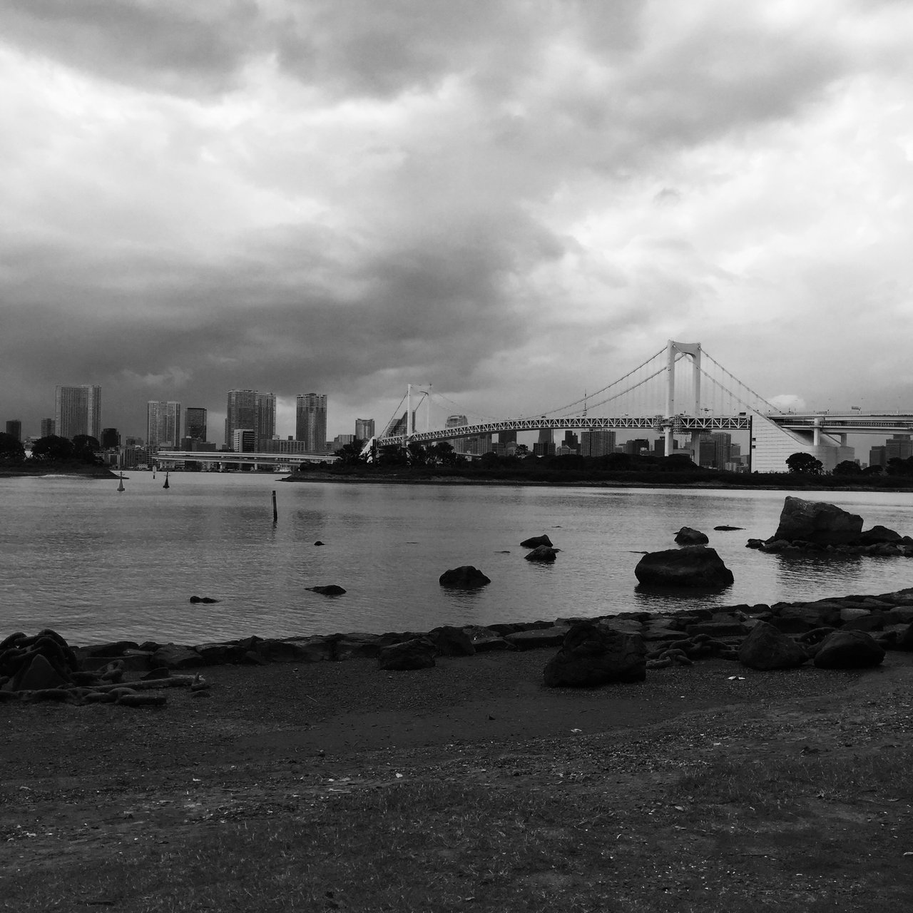 Monochrome bay shore with the suspension bridge across the water