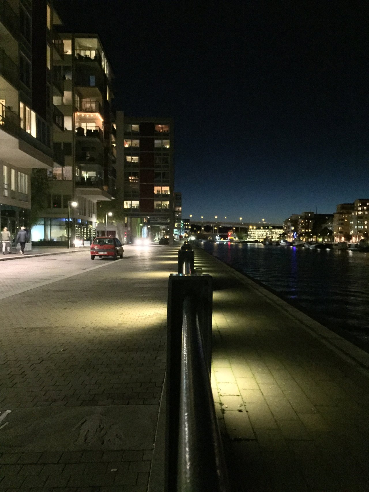 Waterfront promenade at dusk, mooring bollard in the foreground