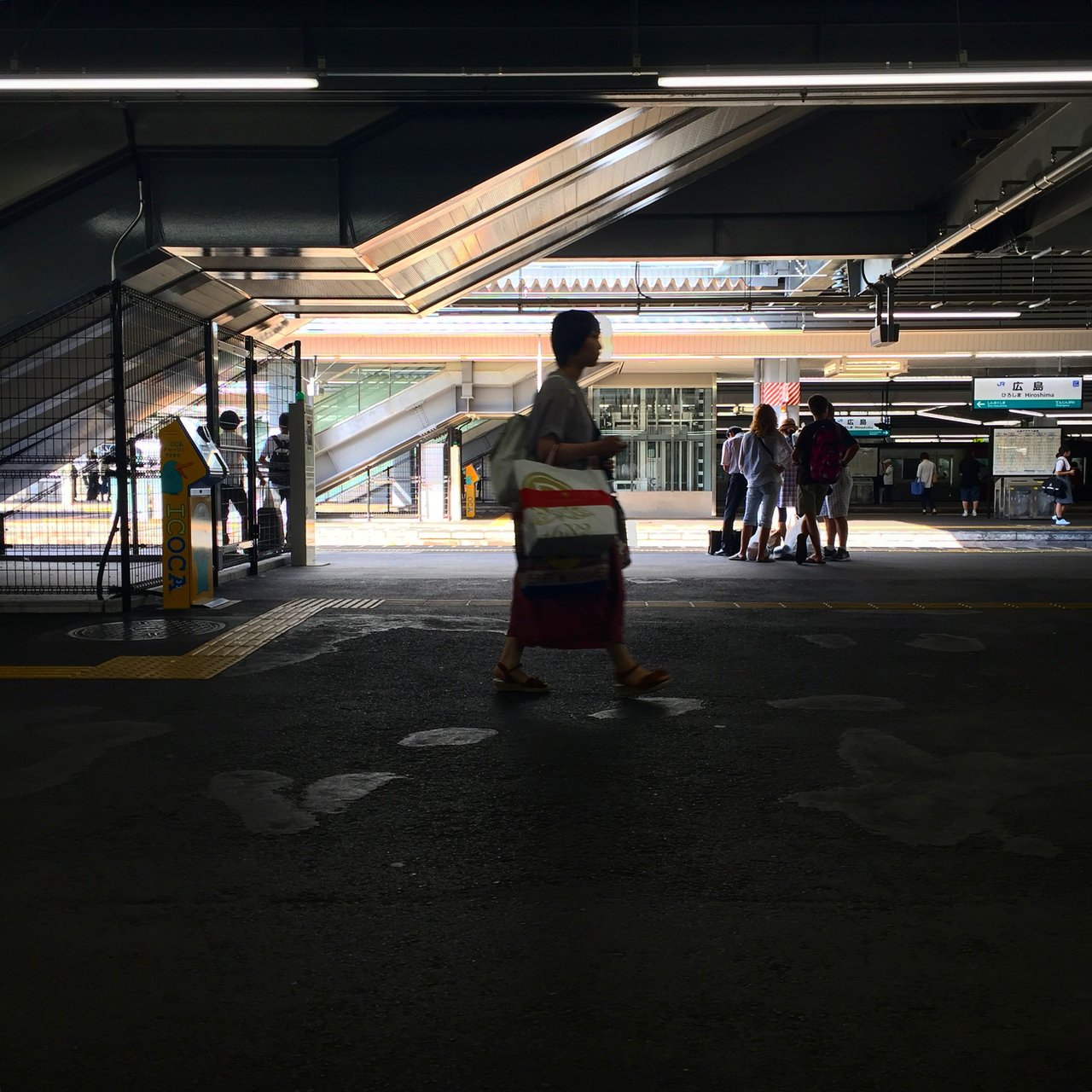 Traveller in a yukata crossing an open station concourse