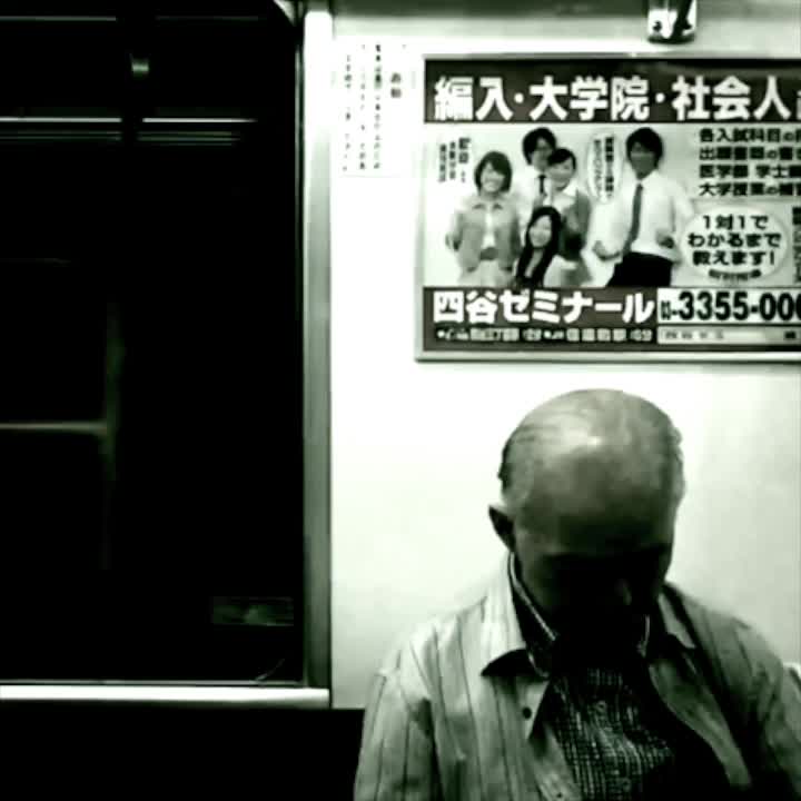 A passenger dozes beneath a cram-school advertisement on a Tokyo Metro train