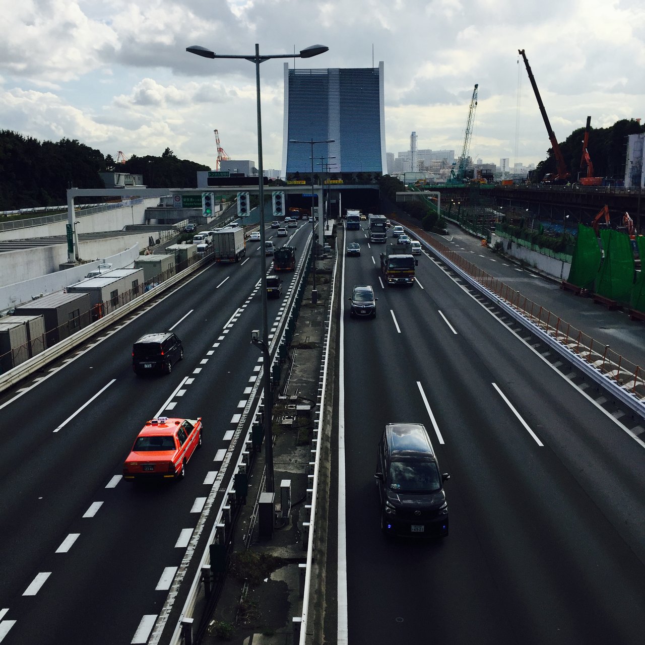 Urban expressway from above, a red taxi among grey traffic