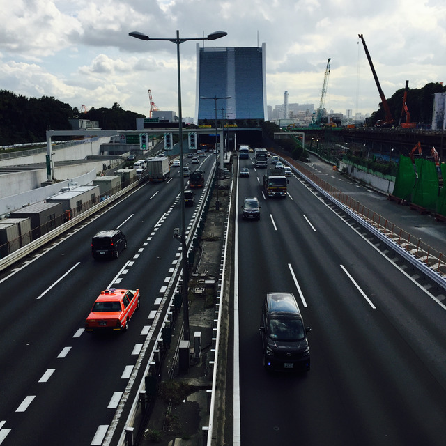 Urban expressway from above, a red taxi among grey traffic