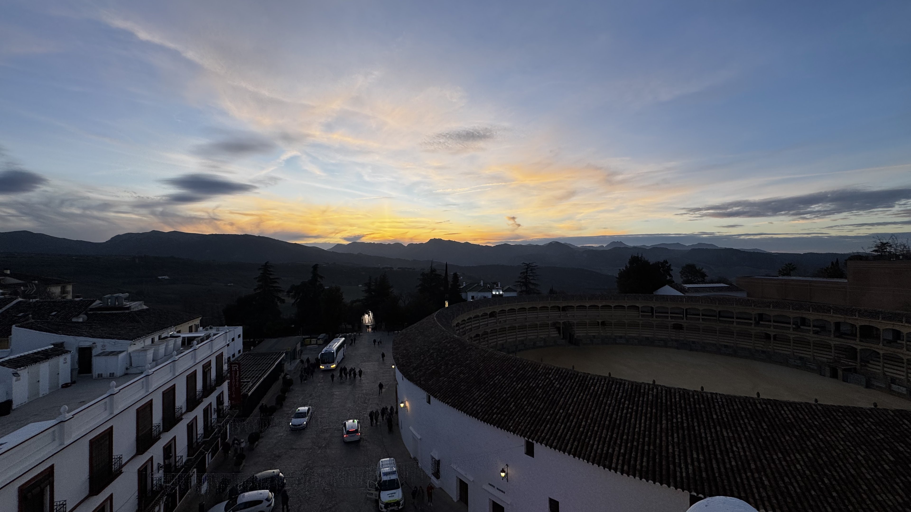 Ronda's bullring and its double gallery at dusk, mountains beyond