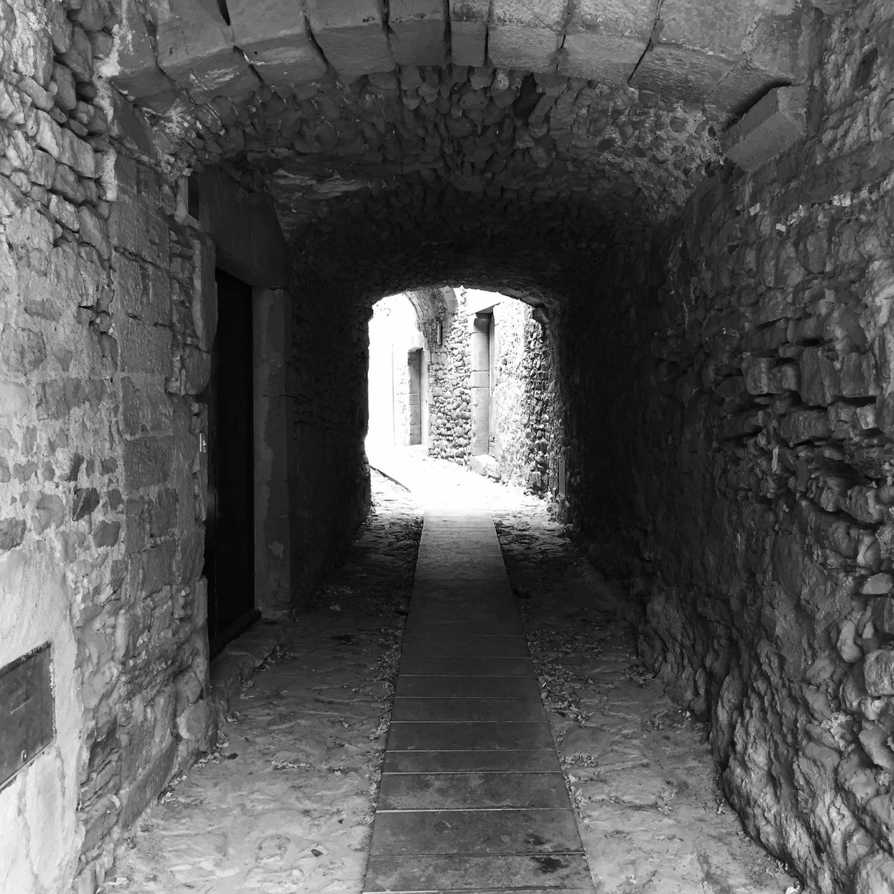 Vaulted stone passage in Madremanya opening to bright daylight
