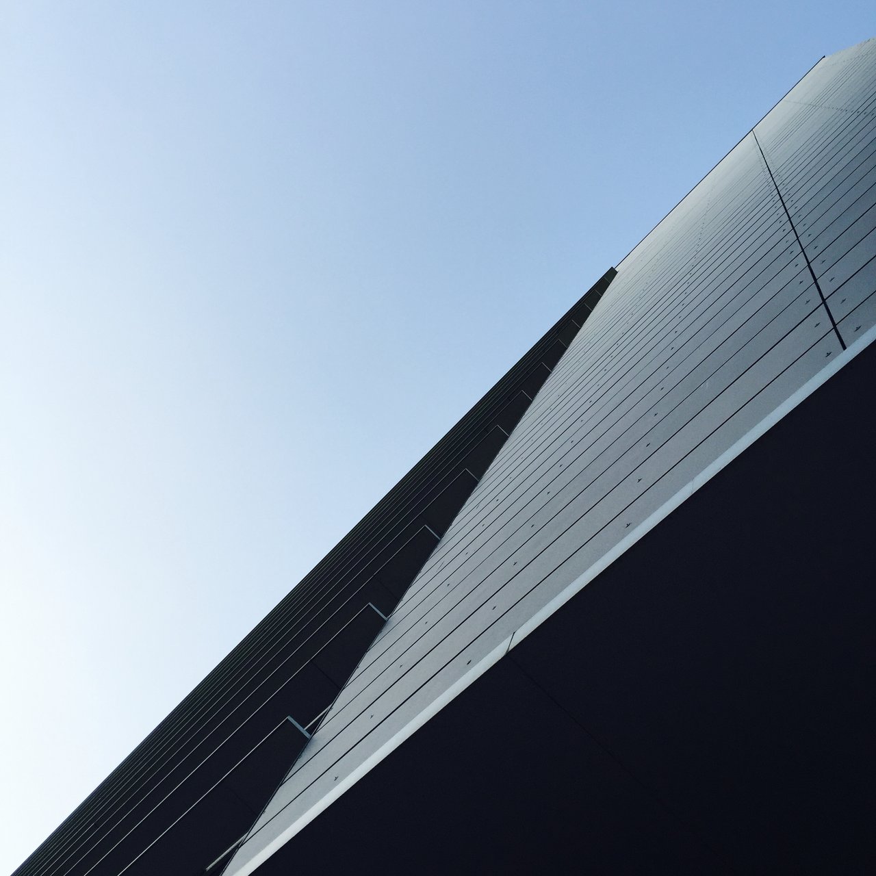 Sharp building edge dividing pale sky from deep shadow