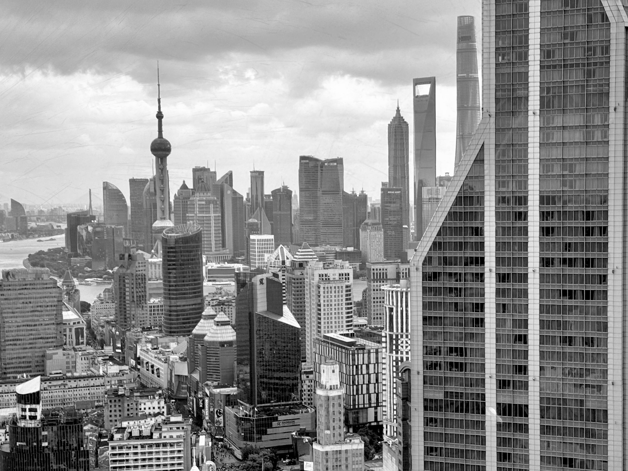 The towers of Lujiazui under heavy cloud, from high across the river