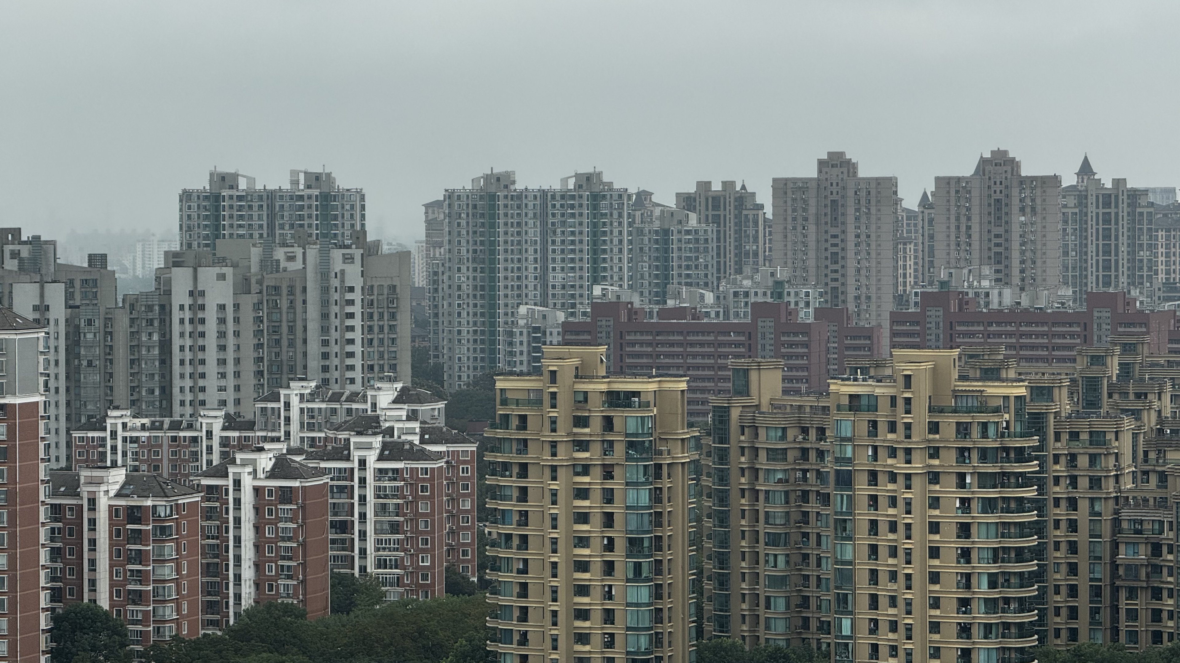 Ranks of Shanghai apartment towers dissolve into haze